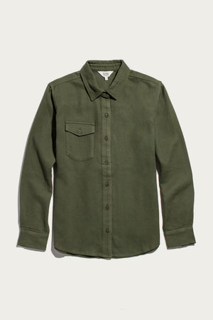The Bird Shirt / Pine Flannel by Bridge & Burn features an olive green hue in a relaxed fit, crafted from organic cotton flannel. This long-sleeve shirt includes a collared neckline and a single chest pocket on the left side, and is showcased against a plain white background.