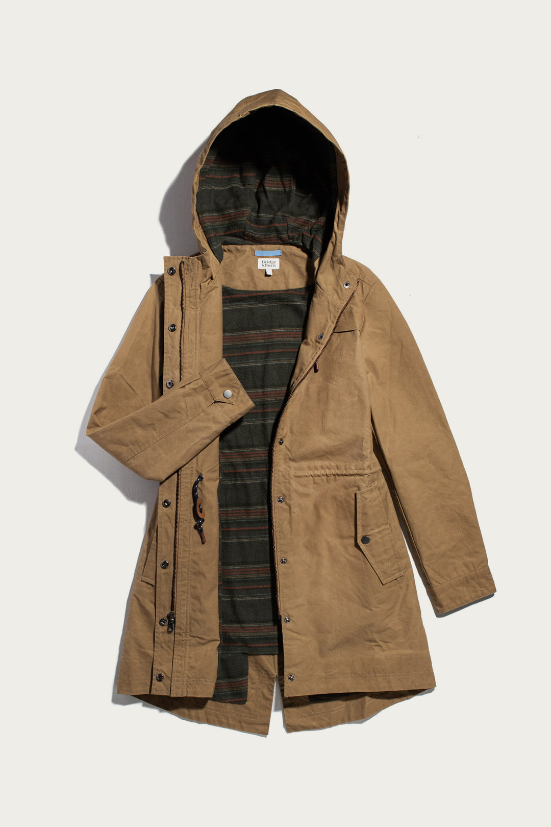 Briar Jacket in dark khaki waxed canvas, featuring a hooded design, button-up placket, and striped lining.