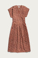 The Ira Dress / Desert Rain by Bridge & Burn is a rust midi pullover with short dolman sleeves, v-neckline, gathered waist, and an abstract white and black dash pattern.