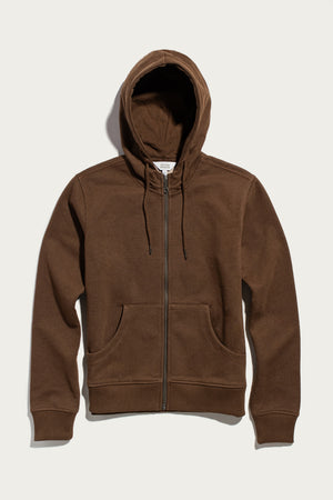 The Bridge & Burn Mason Hoodie in Cumin is a sustainable brown hoodie with a zip-front design, hood and drawstrings, front pockets, and ribbed cuffs and hem, displayed on a light background.