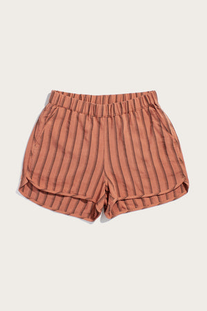 Bridge & Burn’s Luca Track Short in Rust Stripe features peach linen-viscose fabric with vertical brown stripes, an elastic waistband, and side pockets, shown against a plain white background.