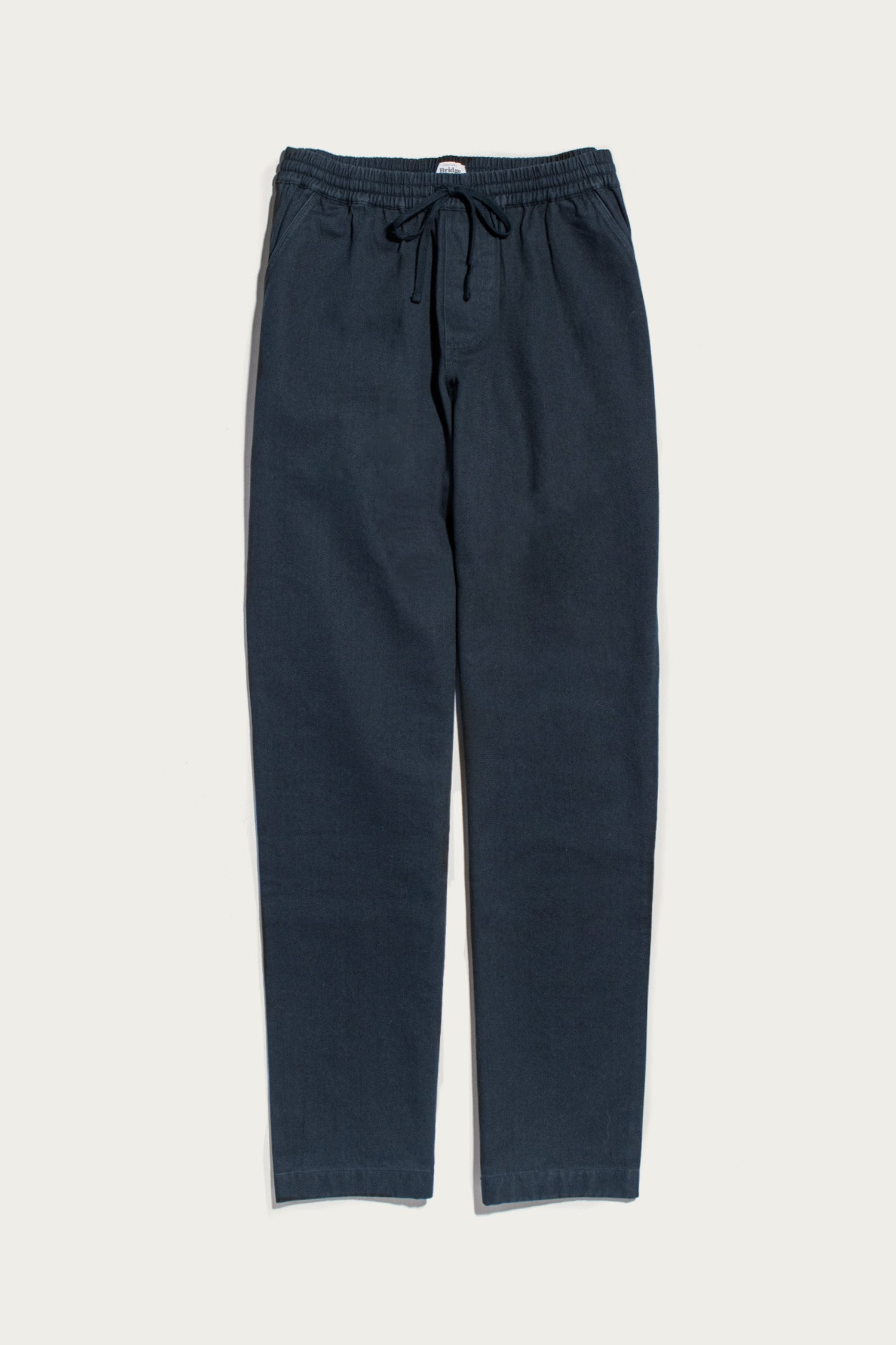 The Bridge & Burn Hayes Pant in Dark Slate is shown laid flat on a white background, featuring an elastic waistband and straight legs for comfortable, relaxed style.