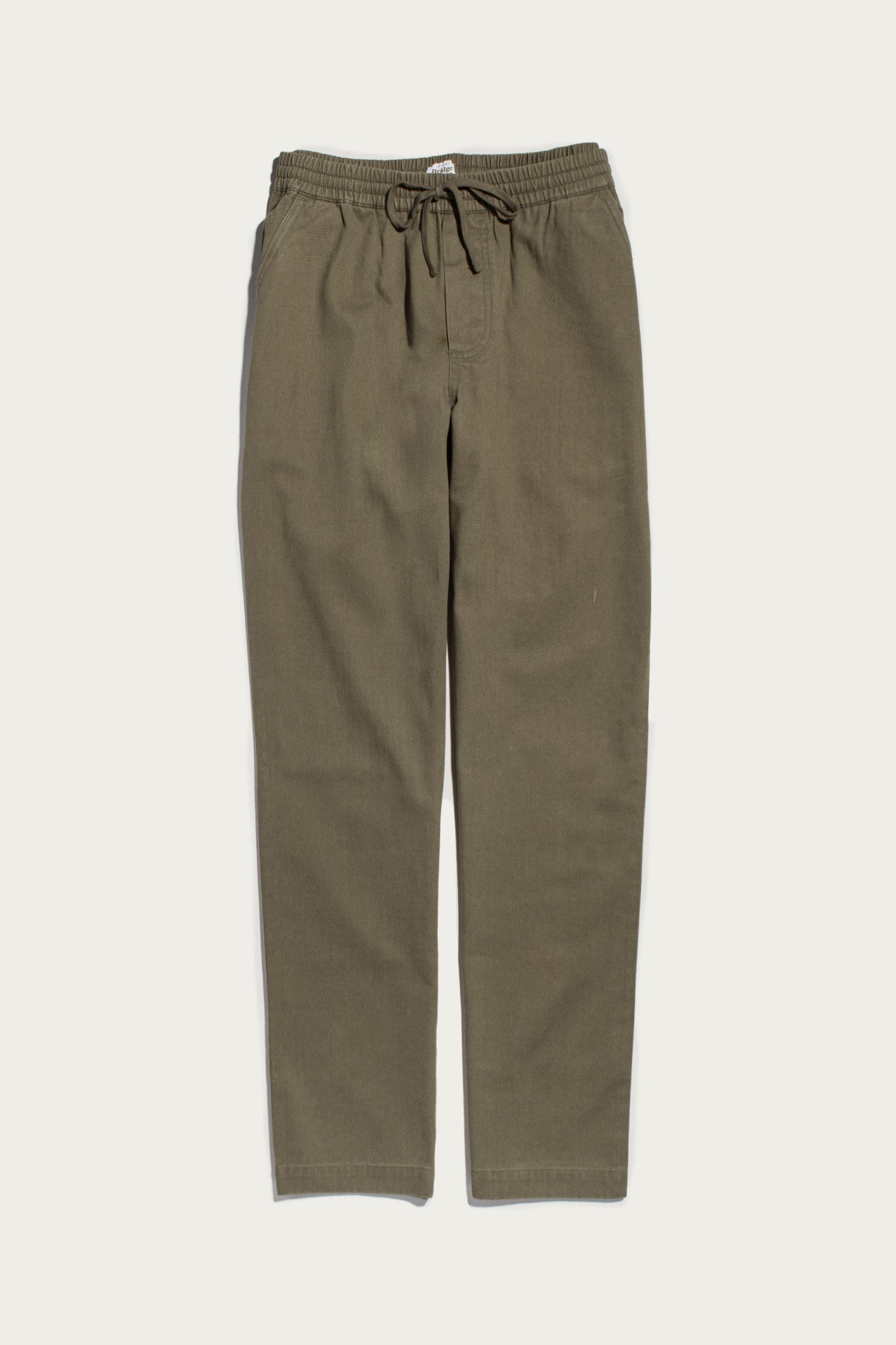 The Hayes Pant in olive by Bridge & Burn features an elastic waistband with a drawstring, straight legs, and a relaxed fit, shown laid flat on a plain white background.
