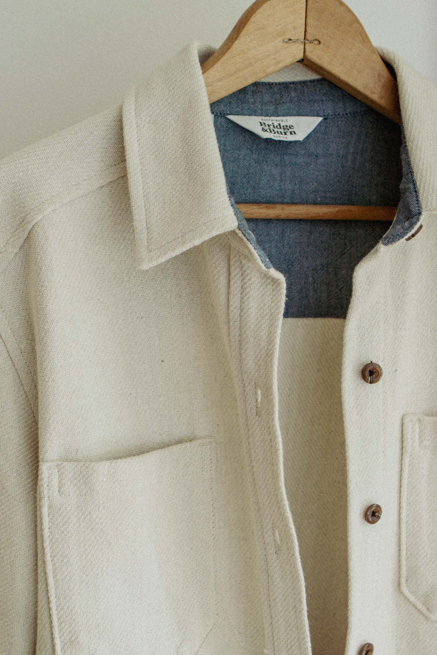 A close-up of the Dawson Overshirt in Ivory Twill by Bridge & Burn, made from recycled textured fabric and featuring a blue denim collar and lining for a stylish contrast and sustainable detail.