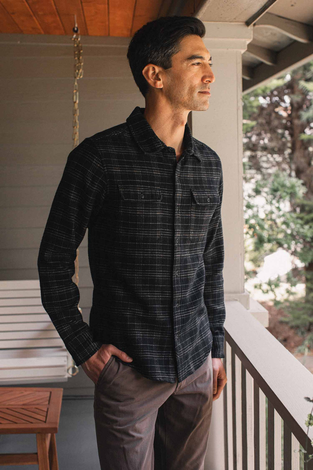 Man wearing a slim fit, black long-sleeve Bridge & Burn Cole Slim Shirt / Obsidian Grid with a white grid pattern and two chest pockets.