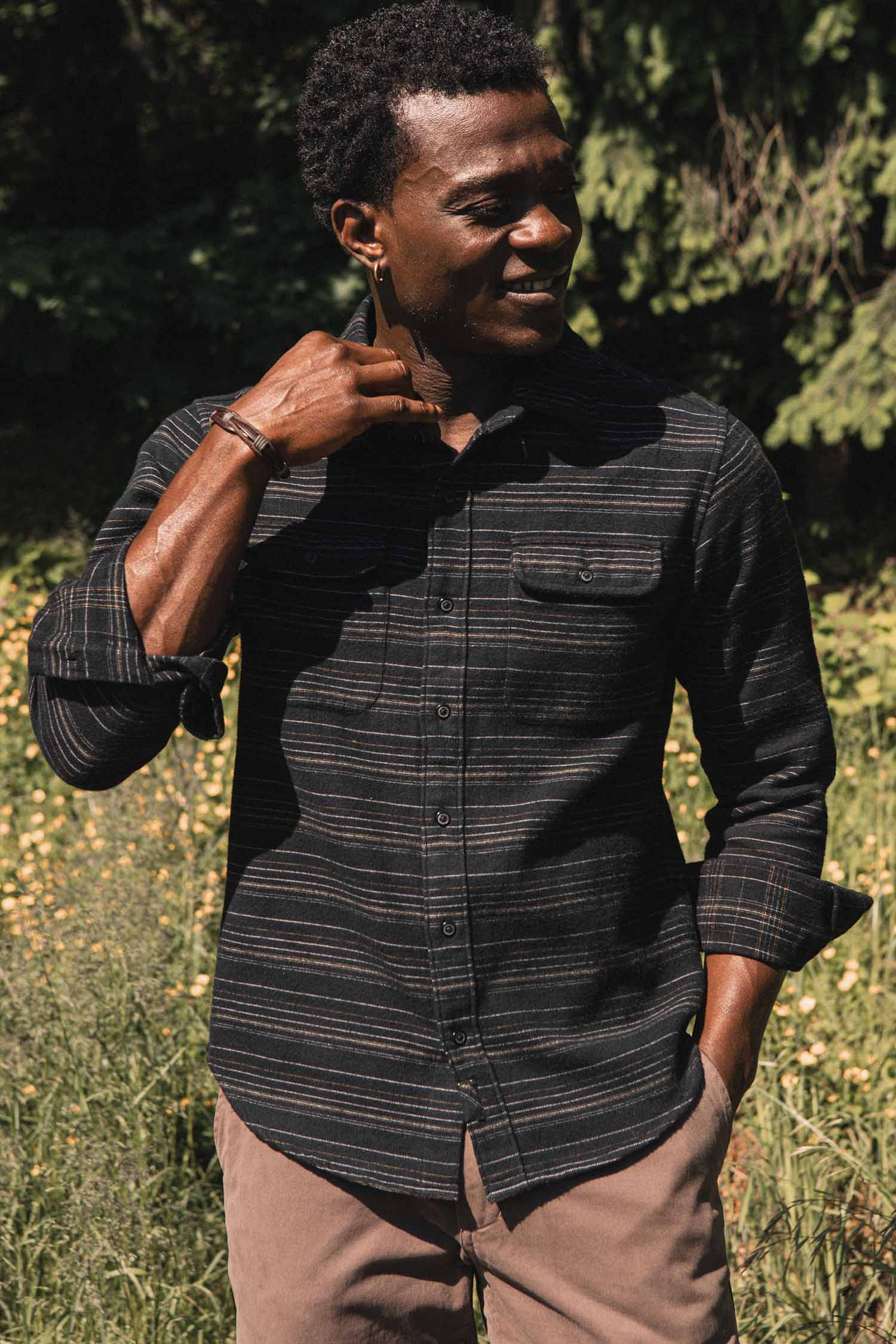 A man wearing a Bridge & Burn Cole Slim Shirt / Raven Stripe, a slim fit, black long-sleeve button-down shirt with horizontal stripes and two chest pockets.
