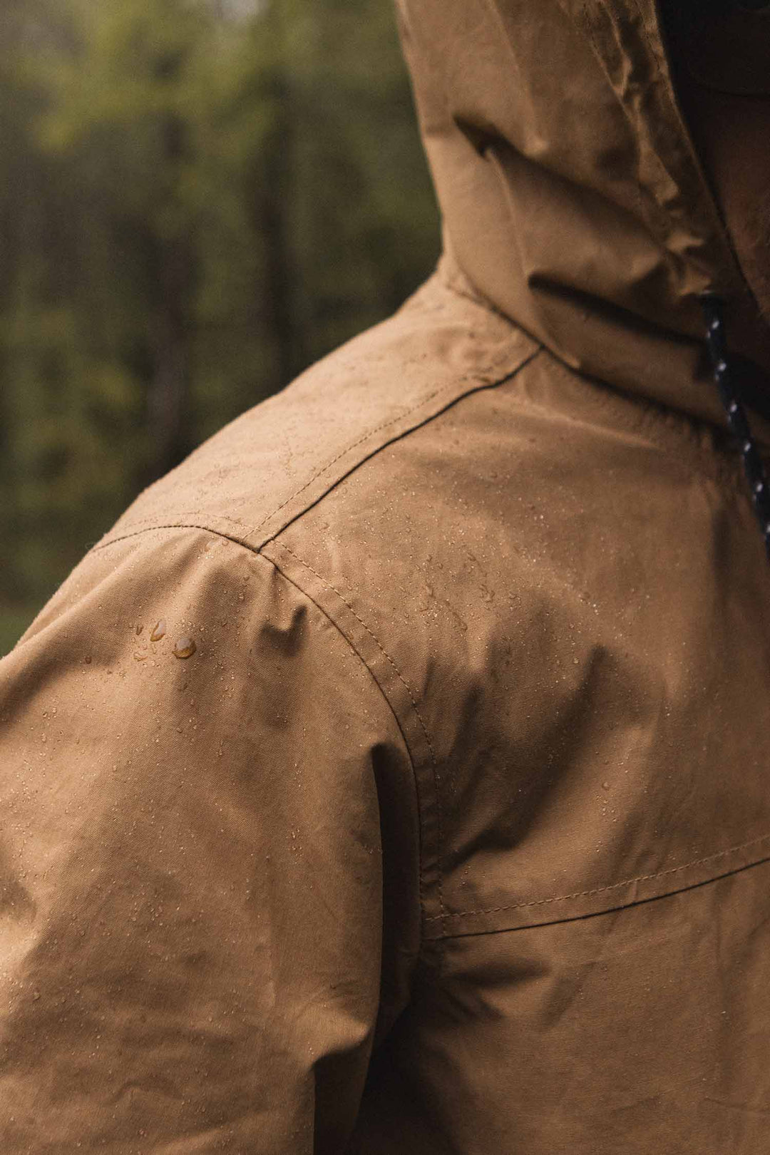 Bridge & Burn Marshall Jacket in Dark Khaki waxed canvas with water droplets on its water-resistant surface.