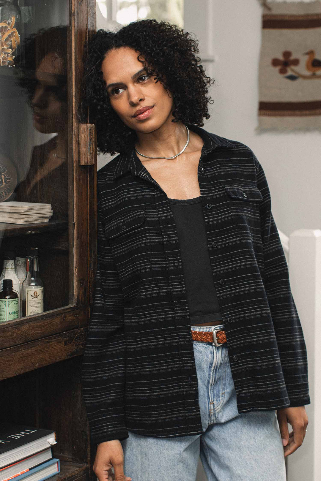 A person wearing a Bridge & Burn Lenon Shirt / Raven Stripe over a black tank top and light-wash jeans.