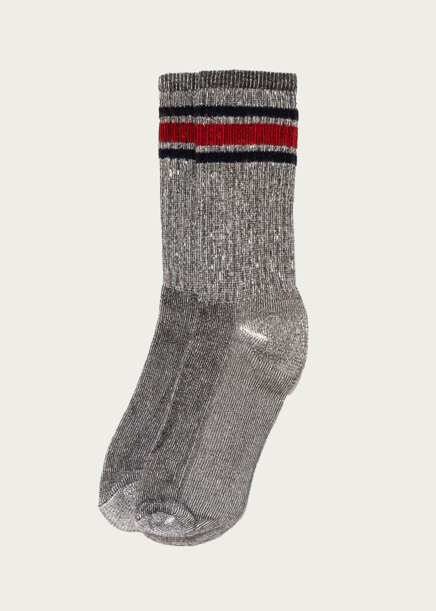 The American Trench - Merino Activity Crew in Grey showcases a pair of crew socks with a subtle metallic sheen, expertly crafted from moisture-wicking Merino wool for day-long comfort. These anti-bacterial socks feature two horizontal stripes—one red and one black—near the top, and are presented against a simple light background.