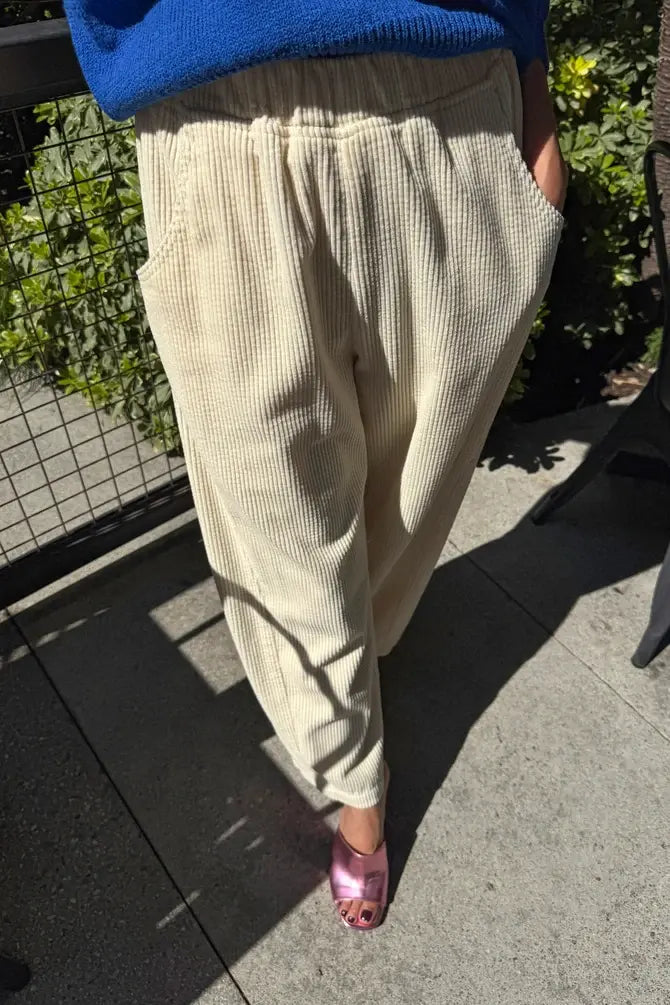 Le Bon Shoppe Soft Corduroy Arc Pant in ecru, featuring an off-white high-waisted corduroy design with an elastic waist and side pockets.