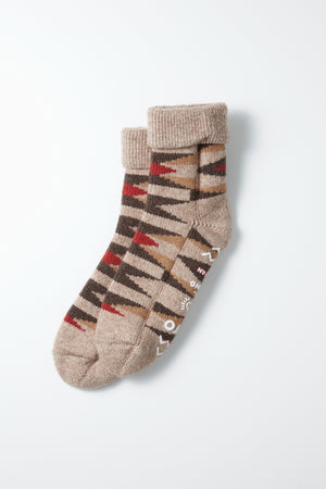 RoToTo Merino Lambs Wool Room Socks "Native" in L. Brown—chunky, Japanese-made slipper socks in beige with brown, red, and black geometric zigzags. Folded at the cuffs and displayed on a white background.
