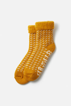 The RoToTo Comfy Room Bird's Eye Socks in dark yellow by RoToTo feature slip-resistant soles, white dot patterns, and text near the toes, all shown on a plain white background.