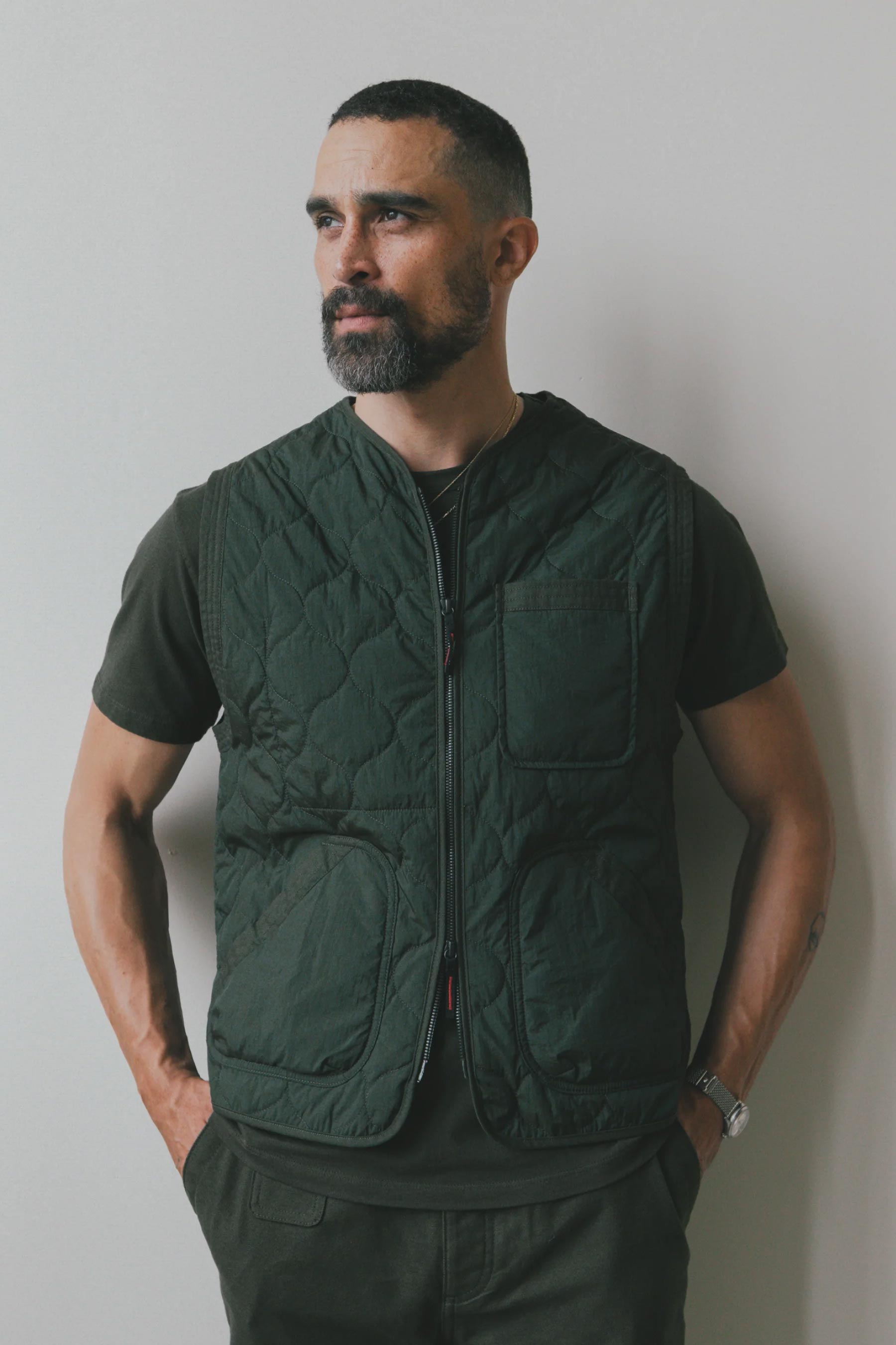 A man wearing an Imperfects - Shokunin Vest in Quilted Nylon / Greenroom over a matching t-shirt.