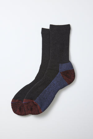 A pair of RoToTo Double Face Merino Pile Socks in Charcoal, featuring a dark gray ribbed merino wool design with red toes and heels, blue accents on the heels and soles, crafted in Japan by RoToTo and displayed against a white background.