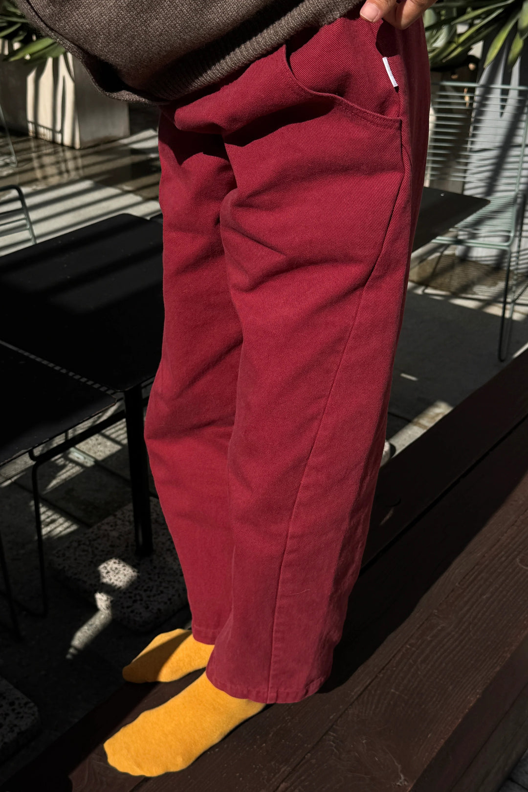 Deep red, high-waisted cropped Le Bon Shoppe Arc Pant in Oxblood with pockets and yellow socks.