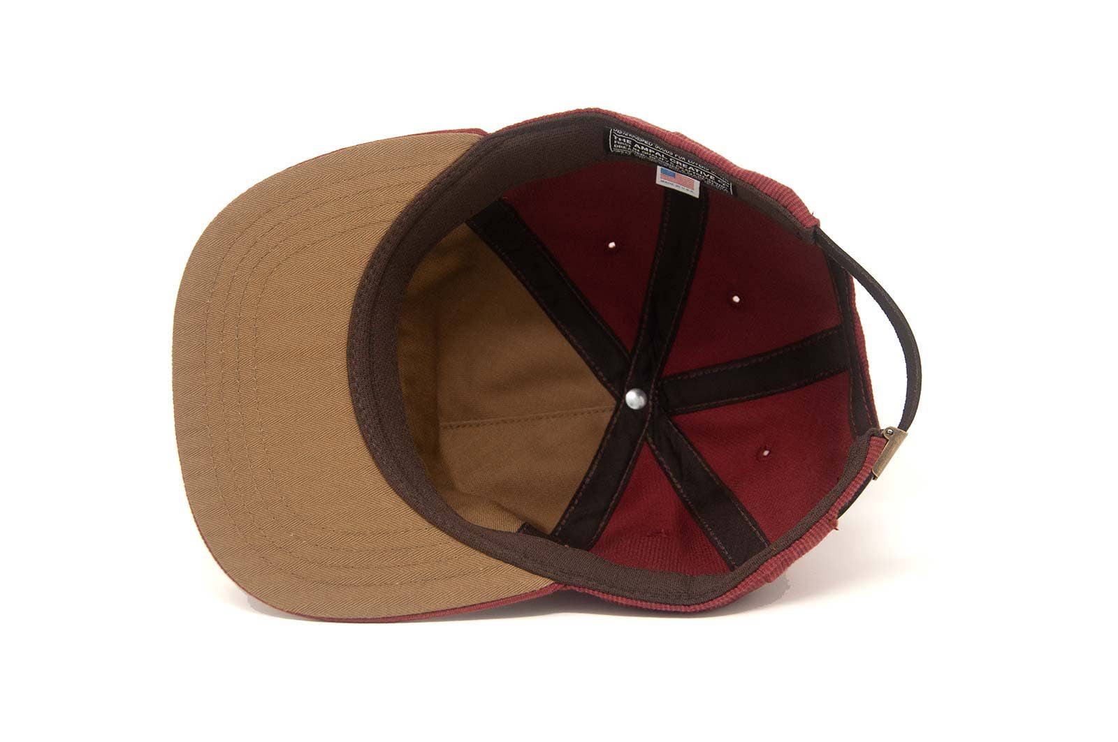 A top-down view of The Ampal Creative - Sunset Cactus / Brick hat, crafted in Los Angeles from cotton Bedford cloth, highlighting its red and brown design, inner lining, stitching, and adjustable back strap.