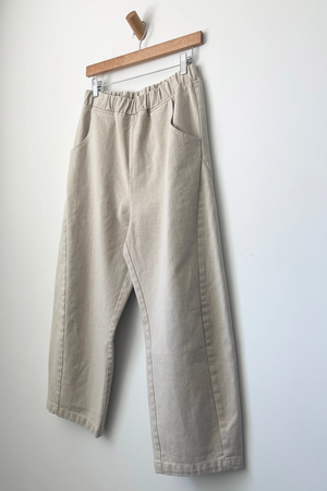 Le Bon Shoppe - Arc Pant / Natural: Heavy-weight canvas wide-leg pants with elastic waistband and side pockets, hangs on a wooden hanger against a plain white wall.