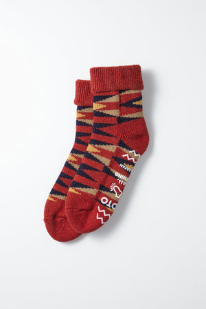 RoToTo Merino Lambs Wool Room Socks "Native" in red feature folded cuffs and a geometric navy, beige, and black pattern. "ROTOTO" and "MADE IN JAPAN" are on the soles—a perfect cozy winter gift from RoToTo.