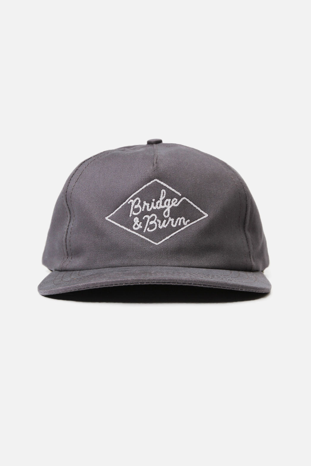 The Diamond Head Cap / Grey by Bridge & Burn is a gray cotton twill hat featuring “Bridge & Burn” embroidered in white inside a diamond shape on the front. It has a leather adjustment strap at the back, is made in the USA, and is shown against a plain white background.
