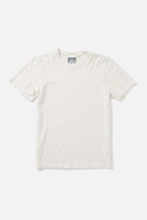 The Jungmaven Baja Tee in Washed White is laid flat on a white background. This organic cotton crewneck tee, made in the USA, features a visible collar tag and minimalist design.