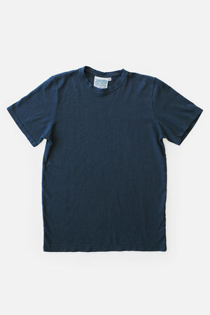 The Jungmaven Baja Tee in navy, made in the USA from soft organic cotton, is shown laid flat on a white background with a small brand label at the back of the neck.