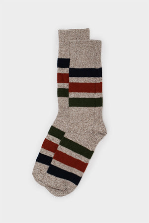 The RoToTo Park Stripe Crew Socks in beige feature chunky horizontal stripes in dark green, navy blue, and rust red, shown laid flat on a light gray background. Brand: RoToTo.