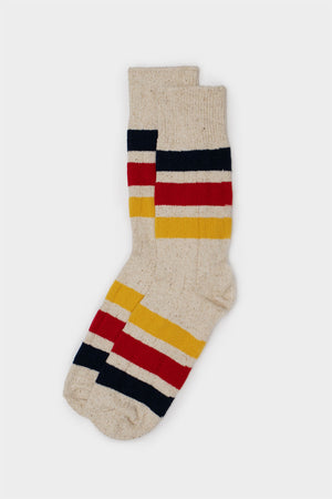 A pair of RoToTo Park Stripe Crew Socks in ivory, featuring horizontal red, navy blue, and yellow stripes near the ankle and foot, displayed against a plain light background.