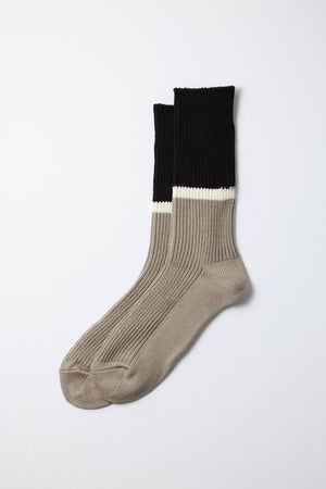 RoToTo Rototo Bicolor Ribbed Socks in Black Grey feature comfortable ribbing, beige feet and ankles, a white stripe above the ankle, and black cuffs, shown on a plain light gray background.
