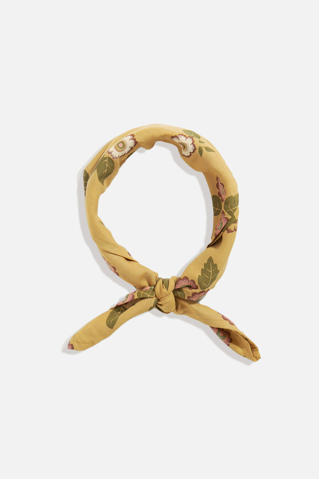 The Bridge & Burn XL Bandana in Folk Floral, featuring a yellow floral pattern, is tied in a loose knot and arranged in a circular shape on a white background.